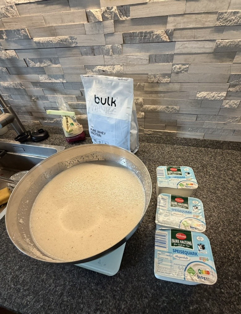 Drei Quarkbecher neben einer großen Schüssel mit der Puddingmischung